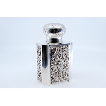 Frasco de perfume em prata ao gosto asiático com gravados na tampa e relevos na envolvência. 